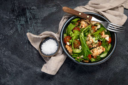 Fresh chicken salad on drak gray background. Healthy food concept. Top view, flat lay, copy spaceの写真素材