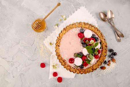 Strawberry vanila tart topped with berries on light gray background. Top view, flat lay, copy spaceの写真素材