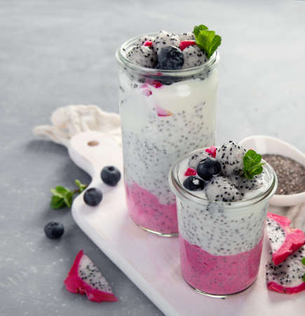 Layered chia puding with pink filling on gray background. Healthy breakfast concept.の写真素材