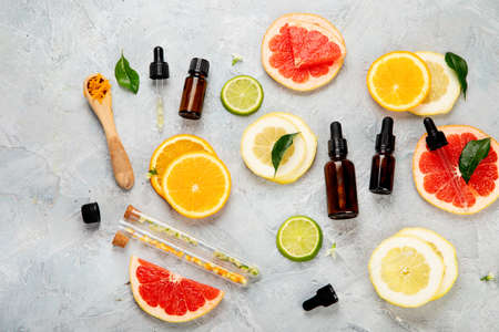 Bottle of essential aroma oils with citrus on light gray background. Top view, flat lay, copy spaceの写真素材