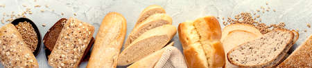 Various types of fresh baked bread on light gray background. Top view, flat lay, copy space,...