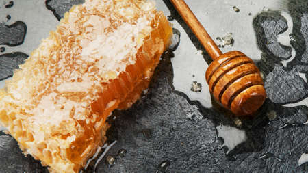Honeycomb and honey in bowl on dark background. Organic food concept. Top view, flat lay, copy spaceの写真素材