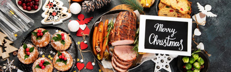 Christmas dinner table setting on dark background. Holiday season concept. Top view, flat lay, panoramaの写真素材