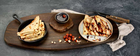 Crepes with sweet toppings on dark background. Homemade food concept. Top view, flat lay, panorama
