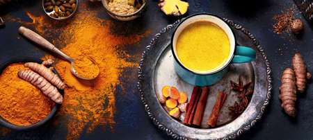 Healthy turmeric golden milk on dark background. Indian traditional drink. Top view, flat layの写真素材