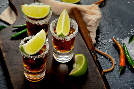 Tequila shots with lime and salt on gray background. Classic bar menu.