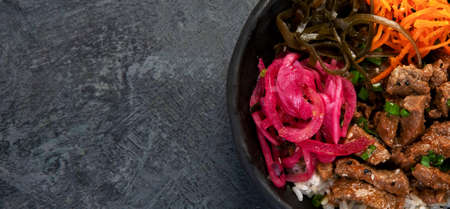 Bulgogi with meat on dark background. Traditional Korean food. Top view, flat lay, copy space