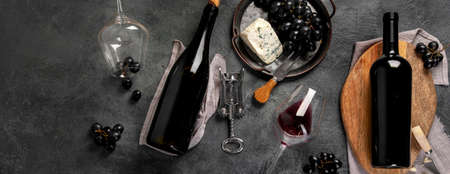 Red wine assortment with appetizers on gray background. Traditional alcohol drinks. Top view, flat...