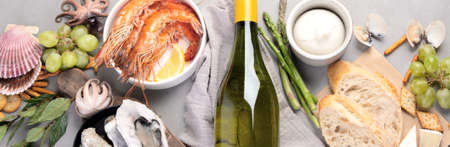 White wine bottle on gray background. Seafood and appetizers. Top view, flat lay, panoramaの写真素材