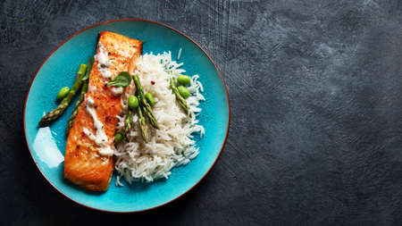 Baked salmon with rice and asparagus on gray background. Mediterranean diet concept. Flat lay, top...