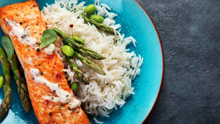 Baked salmon with rice and asparagus on gray background. Mediterranean diet concept. Flat lay, top view, copy spaceの写真素材