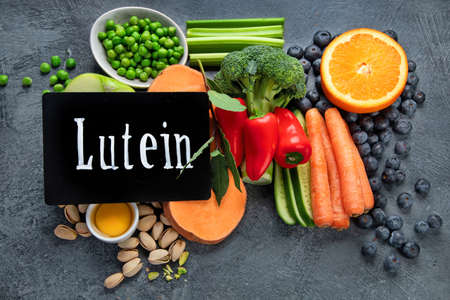 Foods high in lutein on dark background. Food for healthy eyes. High in antioxidants, minerals and vitamins. Top view, flat lay, copy spaceの写真素材