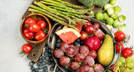 Delicious raw fruits and vegetables on light background. Healthy food concept. Top view, flat lay, copy spaceの写真素材