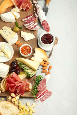 Cheese assortment on light background. Gourmet appetizers on tray. Italian food concept. Top view,...