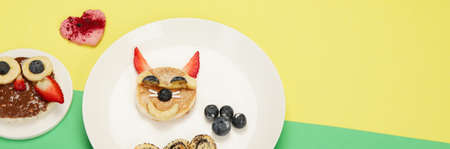 Healthy toasts for kids on colorfull background. Healthy breakfast idea. Playful lunch. Top view, flat lay, copy space, panoramaの写真素材