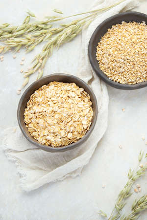 Dry oatmeal in bowl on light background. Healthy breakfast. Dieting and weight loss concept. Flat lay, top view, copy spaceの写真素材
