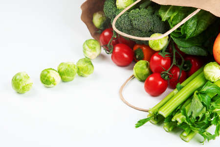 Raw vegetables on light background. Grocery bag. Healthy vegan vegetarian food.