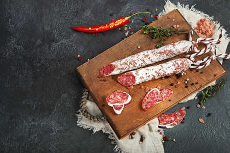 Traditional Spanish fuet on gray background. Dry cured pork sausages with a peculiar taste. Flat lay, top view, copy spaceの写真素材