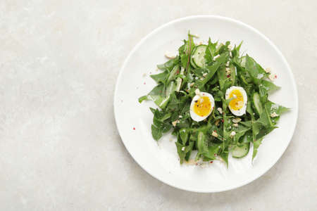 Fresh dandelion salad on light background. Edible plant and nectariferous. Top view, flat lay, copy spaceの写真素材