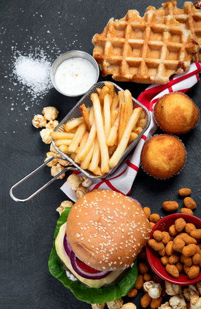 unhealthy products. food bad for figure, skin, heart and teeth. Assortment of fast carbohydrates food with fries and cola on a dark background. top view.の写真素材