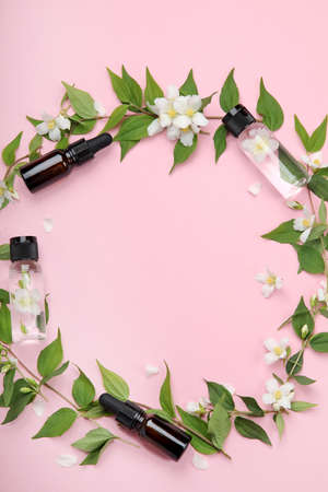 Bottles of essential oils with jasmine flowers. Natural cosmetics and beauty products for body and face care. Top view, flat lay, copy spaceの写真素材