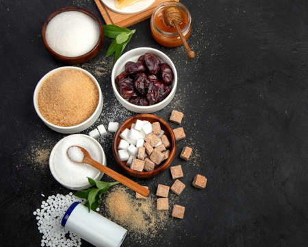 Various diet replacement for sugar on dark background. Organic sweetener concept. Top view, flat...