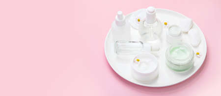 Face and body care products assortment on pink background. natural cosmetics. panorama, copy space