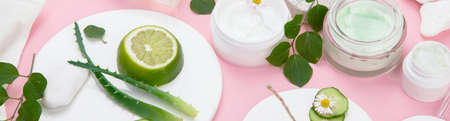 Face and body care products assortment on pink background. natural cosmetics. panoramaの写真素材