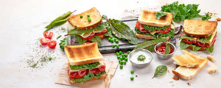 Sandwich with cheese, ham, tomato and fresh salad, made of whole wheat bread with a crispy crust on...