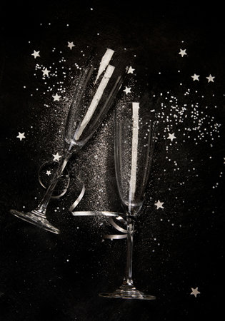 Two champagne glasses. Christmas decoration on a black background. Happy New Year Celebration. top...