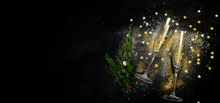 Two champagne glasses and Christmas decoration on a black background background. Happy New Year Celebration. top view.の写真素材