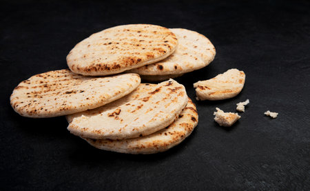 Pita bread isolated on a dark background. Traditional and typical food of Arabic cuisine. top view.の写真素材