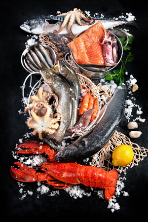 Fresh fish and seafood assortment on black background, fish market. Healthy diet eating concept. top viewの写真素材
