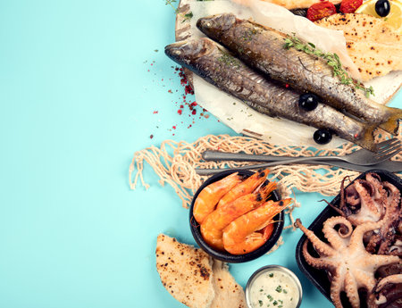 Various seafood and fish dishes. Healthy food concept on blue background, top view, copy spaceの写真素材
