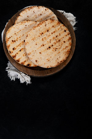 Pita bread isolated on a dark background. Traditional and typical food of Arabic cuisine. top view.の写真素材
