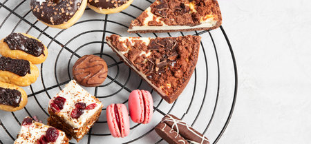 Table with various cookies, donuts, cakes and coffe cups on light backround. top view.の写真素材