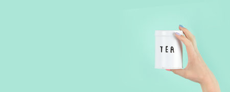 Arms raised up holding tea cup on green background. concept photo. Front view, copy space