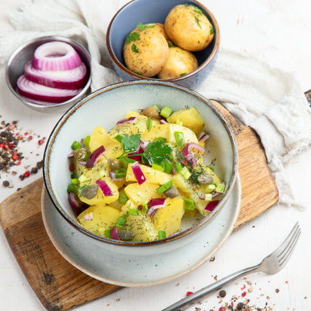 german cuisine. Potato salad with red onions and olive oil in a bowl on a white background. top view.の写真素材