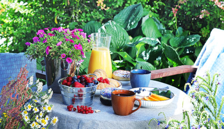Continental breakfast on the garden table. Country lifestyle or weekend morning concept. Peaceful rural scenery. panorama.の写真素材