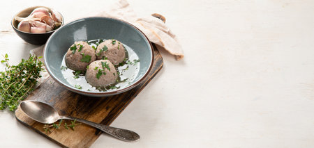Canederli or Knodel in broth with green onion, typical pasta or dumplings for Alps, Alto Adige, German, Italian, Austrian cuisine. Made from stale bread, milk, eggs, speck on a white background. top view. Panorama with copy space.の写真素材