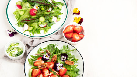 Delicious spring salads with edible flowers, vegetables, fruit, microgreens and cheese on a white background. Clean and healthy eating concept. top view. copyspace.の写真素材