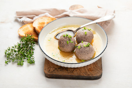 Canederli or Knodel in broth with green onion, typical pasta or dumplings for Alps, Alto Adige, German, Italian, Austrian cuisine. Made from stale bread, milk, eggs, speck. white background. top view.の写真素材