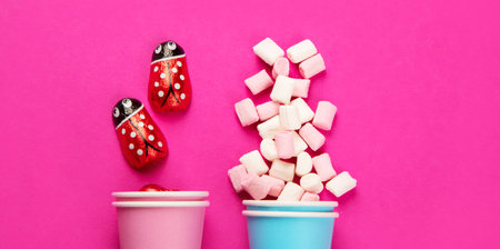 Assorted multicolored sweet jelly candies and marshmallows in eco cups on pink background. top view.の写真素材