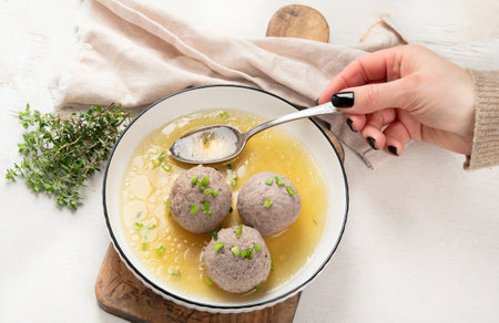 Canederli or Knodel in broth with green onion, typical pasta or dumplings for Alps, Alto Adige, German, Italian, Austrian cuisine. Made from stale bread, milk, eggs, speck. white background. top view.の写真素材