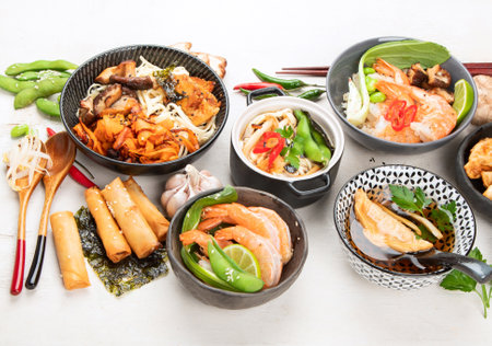 Assorted Chinese food set. Chinese noodles, fried rice, dumplings, peking duck, dim sum, spring rolls. Famous Chinese cuisine dishes on a white background. top view. Chinese restaurant concept. Asian style banquet.の写真素材