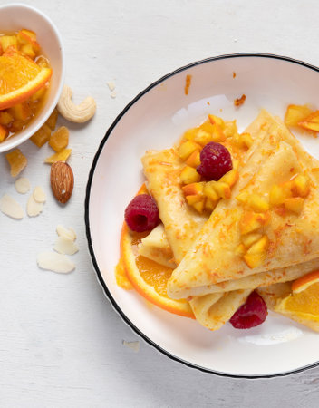 Traditional French crepe Suzette with orange sauce in a white plate on a white background. top view. copyspace.の写真素材