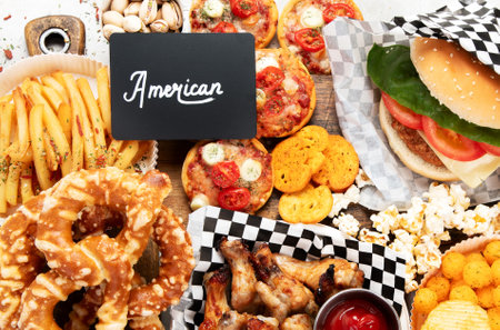 Table scene with large variety of take out and fast foods. Hamburger, pizza, fried chicken and snacks on a white background. top view.の写真素材