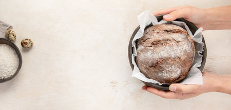Baker or cooking chef holding fresh baked bread in hands on a light background. Concept of cooking....