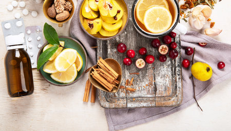 Natural medicinal herbal remedy for cold & flu virus with hot drink with fresh ginger, lemon, honey, cinnamon. echinacea, hawthorn berries and ginseng on a white background. Immune boosting. Copy space.の写真素材