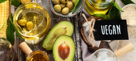 Avocado, almonds, seeds, linseeds, olives and oils on a light background, top view. Alternative oils...